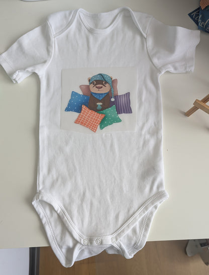 Baby-Body | "Cozy Otter - Kuschelzeit" | für Neugeborene und Kleinkinder | kleiner Otter in mitten von Kissen mit heißer Schokolade in den Pfoten