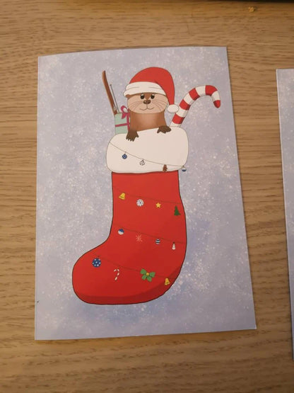 Klappkarte A6 Otter im Strumpf | Grußkarte Weihnachtskarte | Weihnachtsotter im Strumpf mit Geschenken